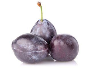 ripe juicy plum with green leaf