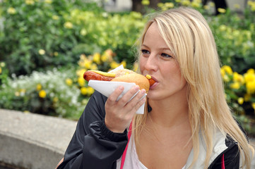 Junge Frau isst Bratwurst