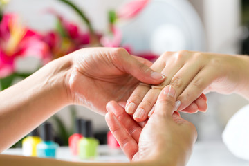 Obraz na płótnie Canvas Kobieta w salonie paznokci otrzymania masaż dłoni