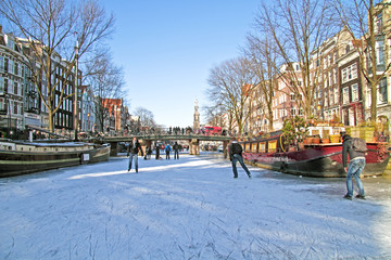 Fototapeta premium Ice skating on the canals in Amsterdam the Netherlands in winter