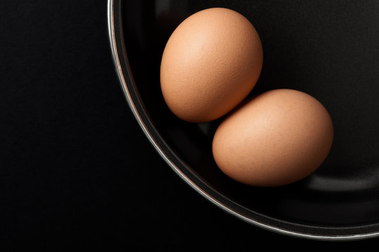Two Brown Chicken Eggs on Black Frying Pan