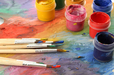 wooden art palette with paint and brushes, close up