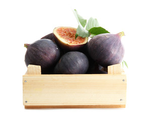 Ripe sweet figs with leaves in wooden crate isolated on white