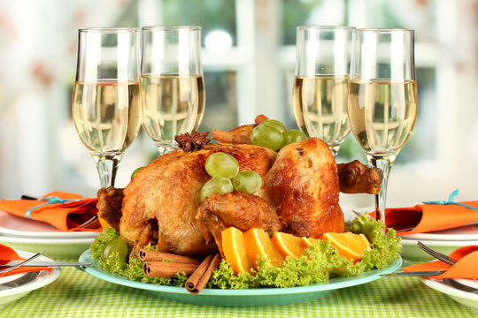 banquet table with roast chicken and glasses of wine.