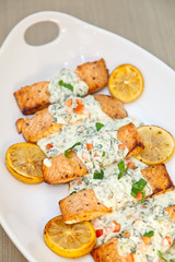 Cooked salmon fillets with spinach sauce on white plate