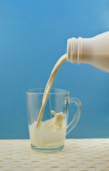 pouring milk from a bottle into a cup