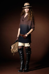 Portrait of pretty young Woman holding handbag In Studio