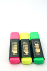 Three colored markers on white background