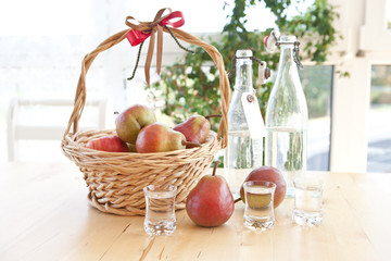 Basket with ripe pears and glasses with pear schnaps