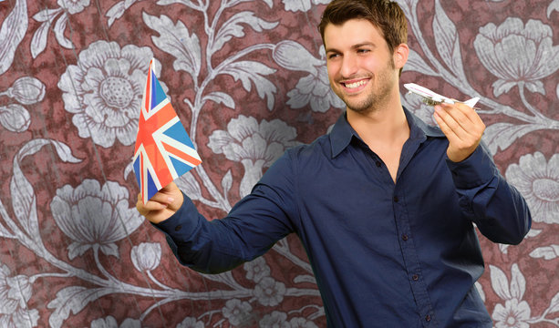 Man Holding A Miniature Airplane And British Flag