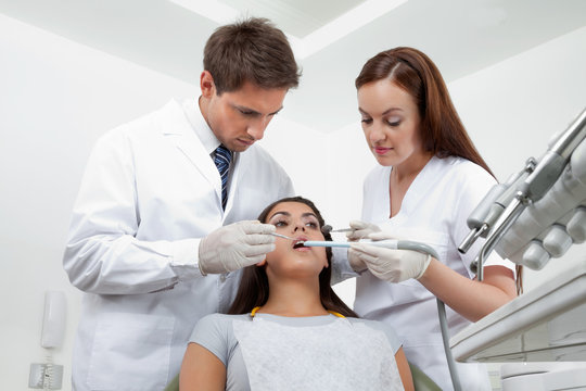 Dentist And Nurse Examining Patient's Teeth