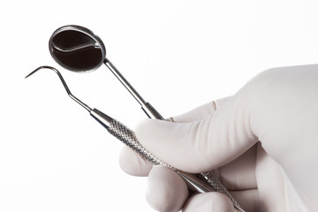 Dentists hands with medical gloves holding dental tools