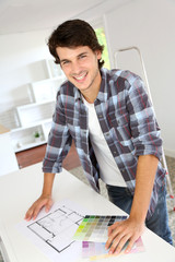 Cheerful young man looking at colours sample for new home