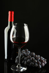 bottle with red wine and glass and grapes