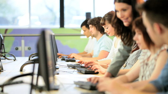 Male and female students working on computer with lecturer 