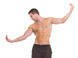 Male athlete with muscular body gracefully posing