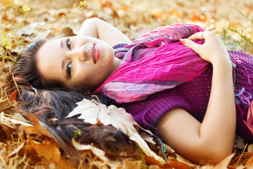 Young woman with autumn leaves in hand