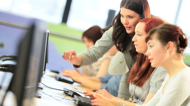 University lecturer helping young students on IT project