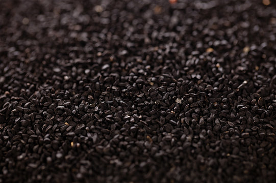 black cumin or caravay or onion seeds backdrop, shallow dof