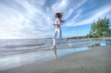 Naklejka premium Sporty woman running in sea coast