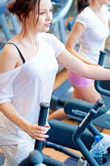 Fototapeta premium Two young sporty women run on machine