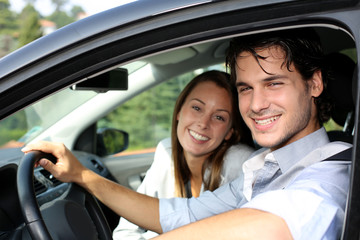 Cheerful couple driving car