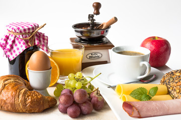 Frühstück mit Kaffee, Wurst, Käse, Ei, Marmelade, Saft und Brot