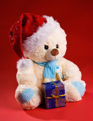 Bear in a festive scarf with a gift