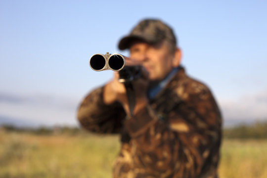 Hunter Taking Aim With A Gun