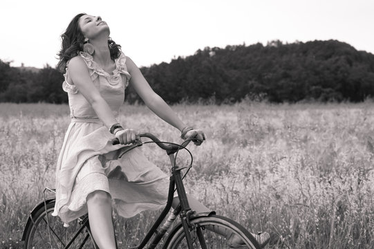 Beautiful black and white image of young woman riding bike
