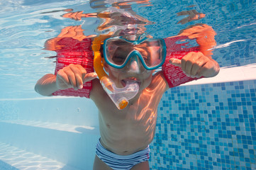 Underwater little kid in swimming pool with musk and armrests. © pio3