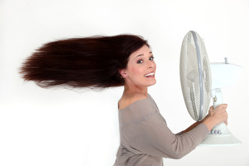 Woman with an electric fan