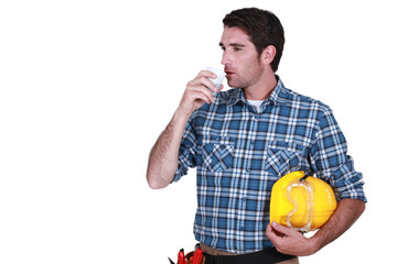 craftsman having cup of coffee hard hat in hand