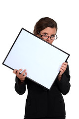 young secretary with glasses lowered holding white board