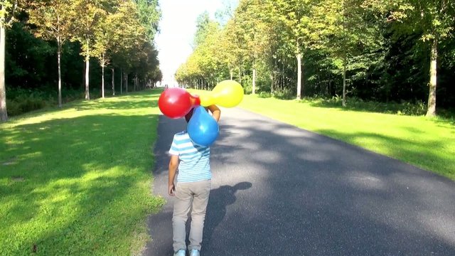 Boy with balloons in the park