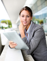 Fototapeta premium Executive woman standing outside with digital tablet