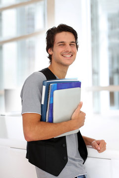 Cheerful college student standing in hall