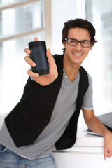 Student in building showing smartphone to camera