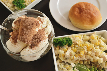 chicken salad, corn, cucumbers, rolls and dessert