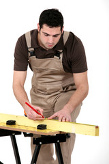 Man measuring plank of wood