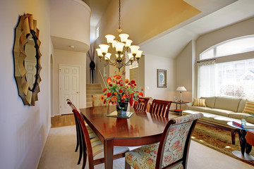 Classic elegant dning room with living room and large window.