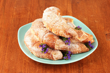Fresh bagels in the plate on wooden background close-up