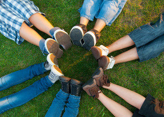 Teenage friends forming circle with their legs