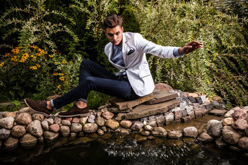 Fototapeta premium young beautiful fashionable man against autumn garden.