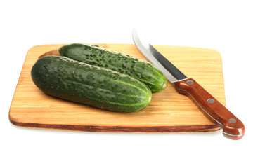 fresh cucumbers and knife on cutting board isolated on white
