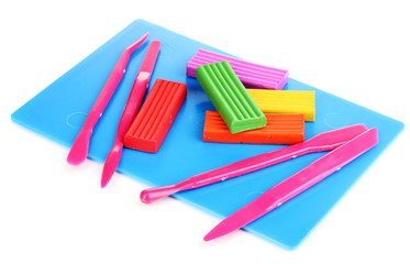 Children bright plasticine on desk with stacks isolated on