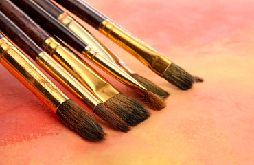 brushes on bright abstract gouache painted background