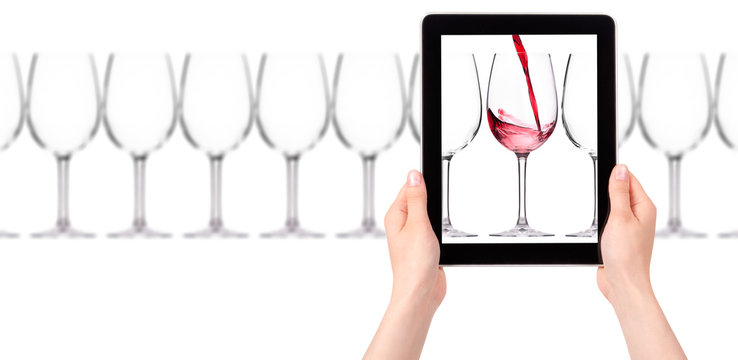 glass of red wine on tablet computer screen