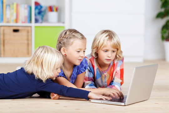 drei mädchen mit laptop im kinderzimmer