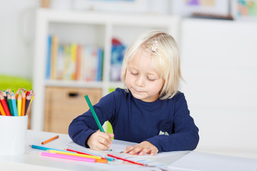 kindergartenkind malt mit buntstiften